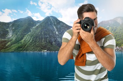 Image of Photographer holding professional camera and picturesque view of mountains and river on background, space for text