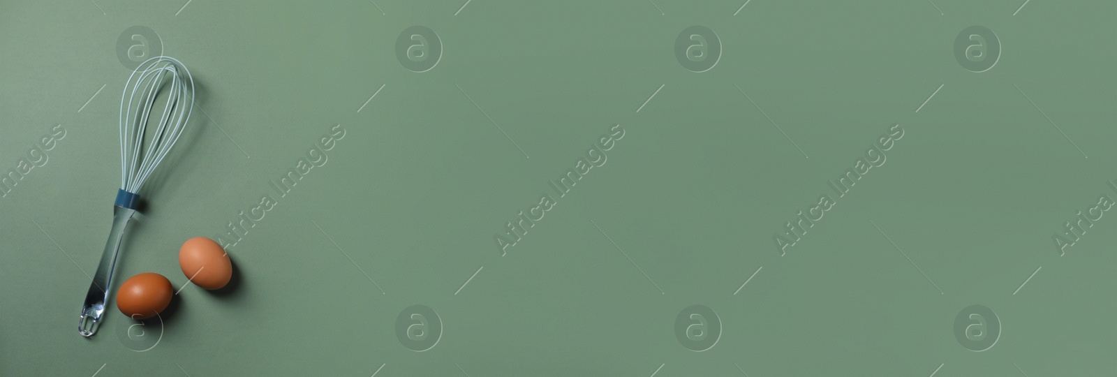 Image of Whisk and eggs on green background, flat lay. Banner design with space for text