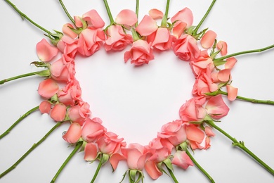 Heart made of beautiful rose flowers on white background