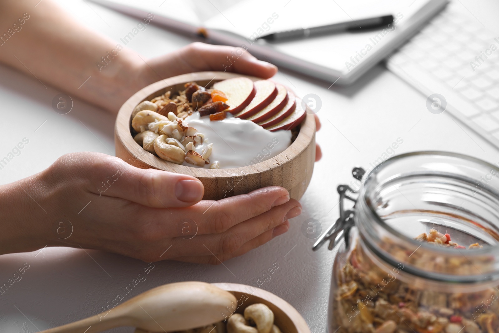 Photo of Woman with tasty granola at workplace, closeup