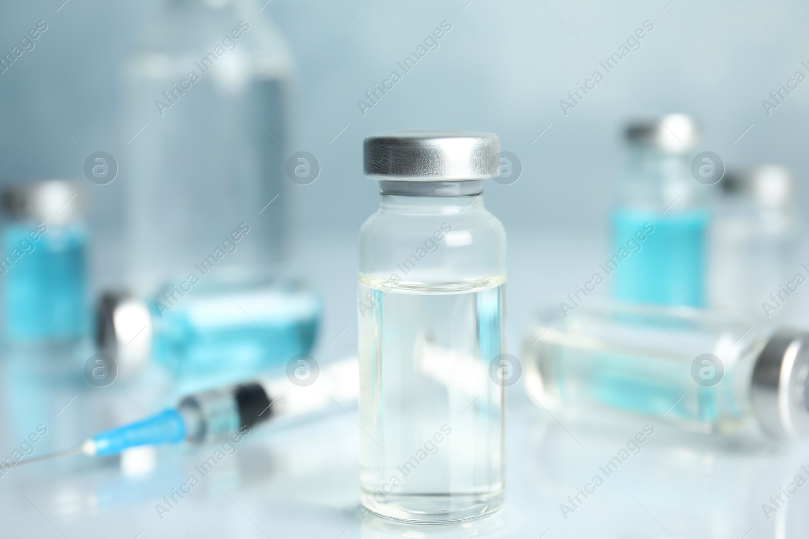 Photo of Vials and syringe on light table. Vaccination and immunization