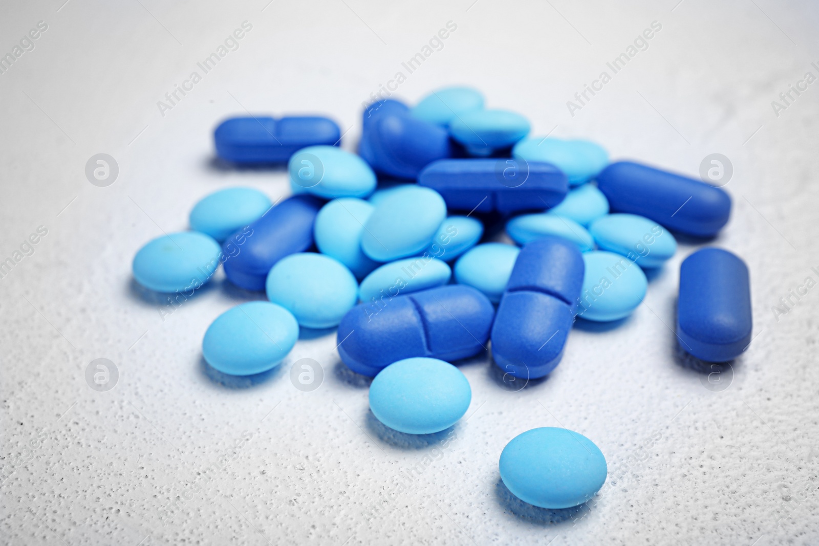 Photo of Blue pills on white background, closeup