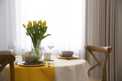 Beautiful Easter table setting with floral decor indoors