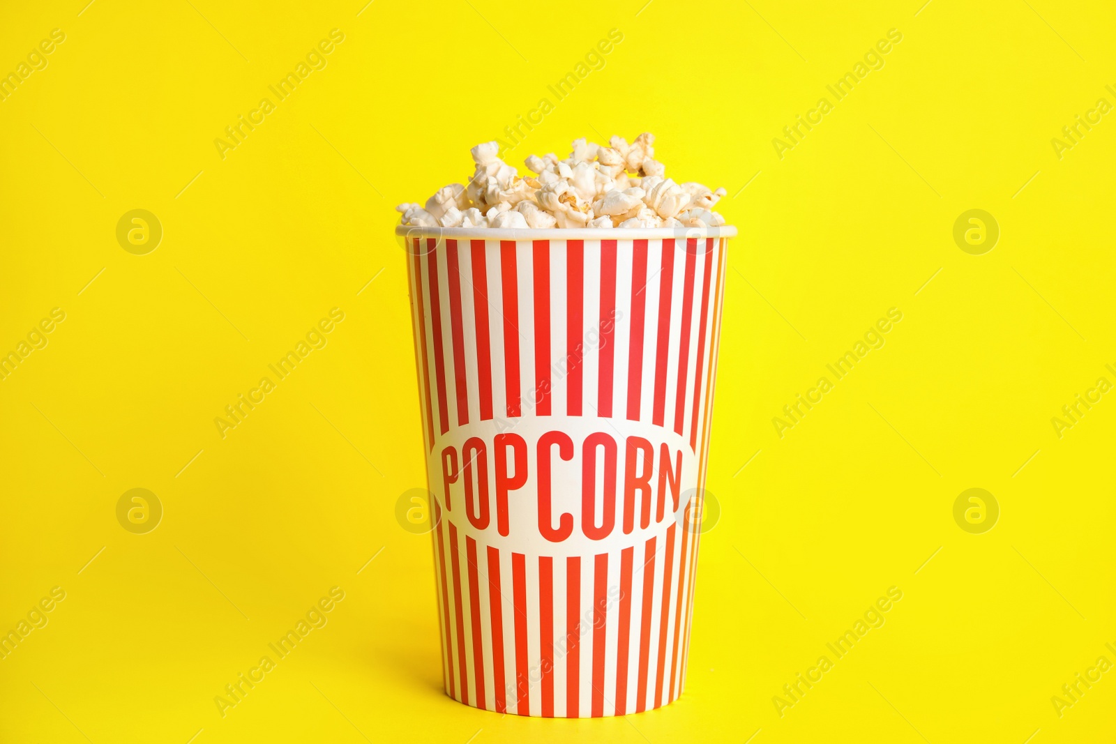 Photo of Tasty fresh pop corn on yellow background