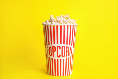 Photo of Tasty fresh pop corn on yellow background