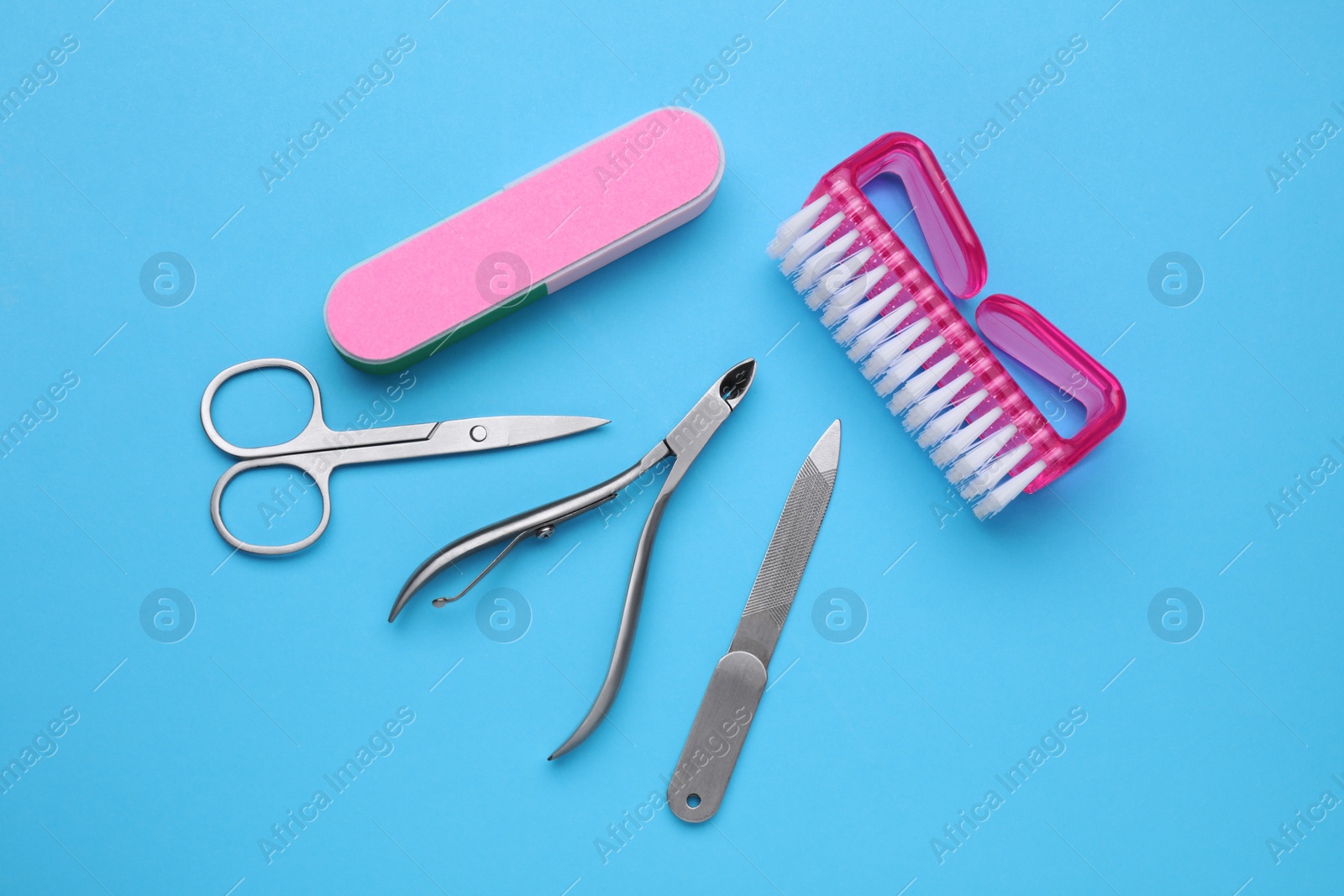 Photo of Set of pedicure tools on light blue background, flat lay