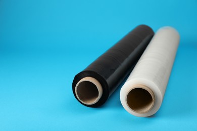 Photo of Rolls of different stretch wrap on turquoise background. Space for text