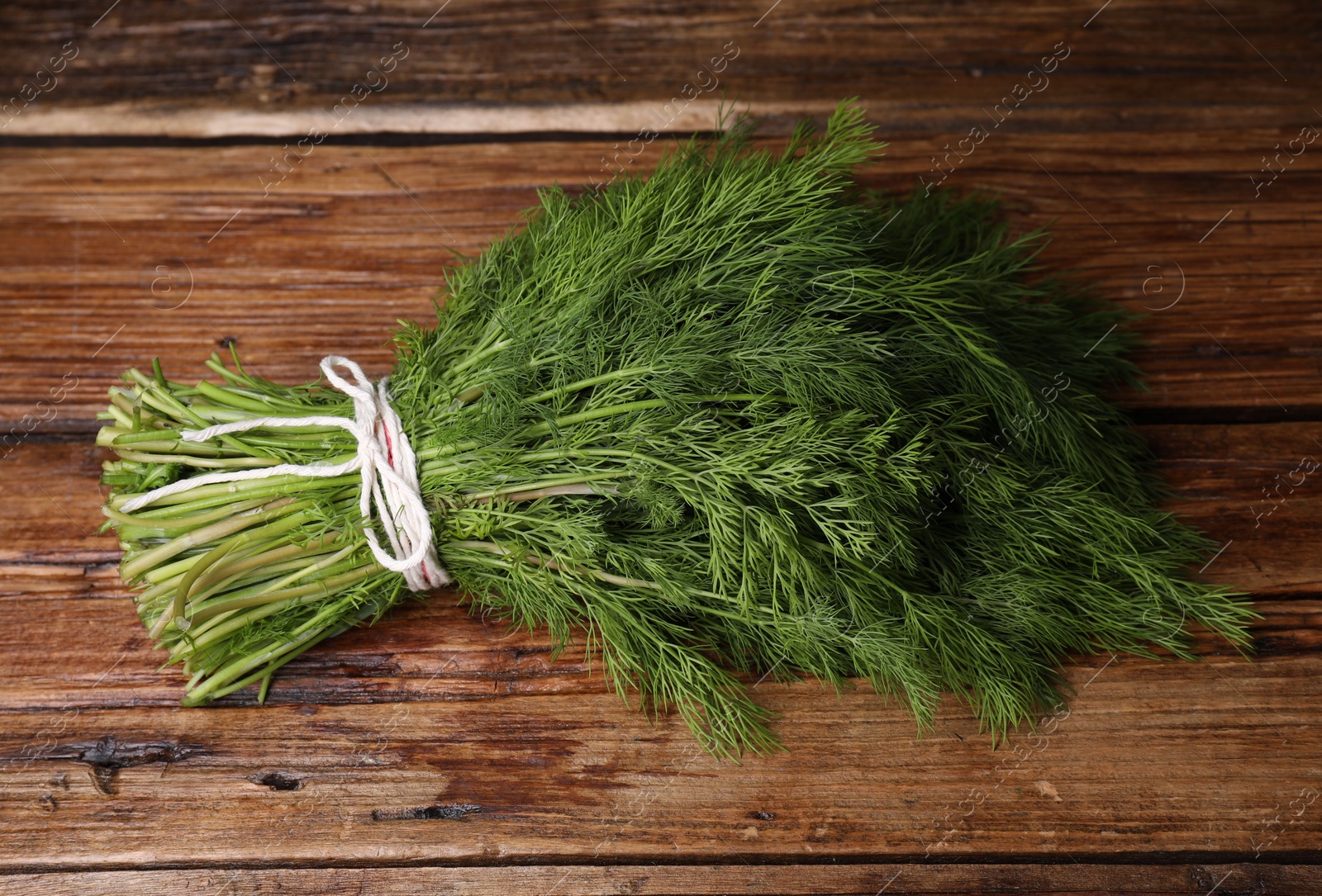 Photo of Bunch of fresh green dill on wooden table