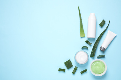 Photo of Flat lay composition with aloe vera and cosmetic products on light blue background. Space for text