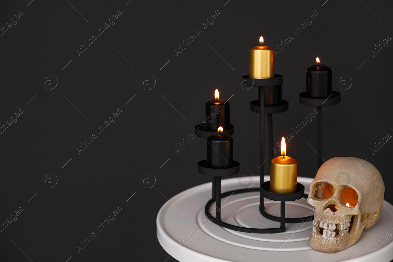 Photo of Halloween decor on table near black wall, space for text. Idea for festive interior