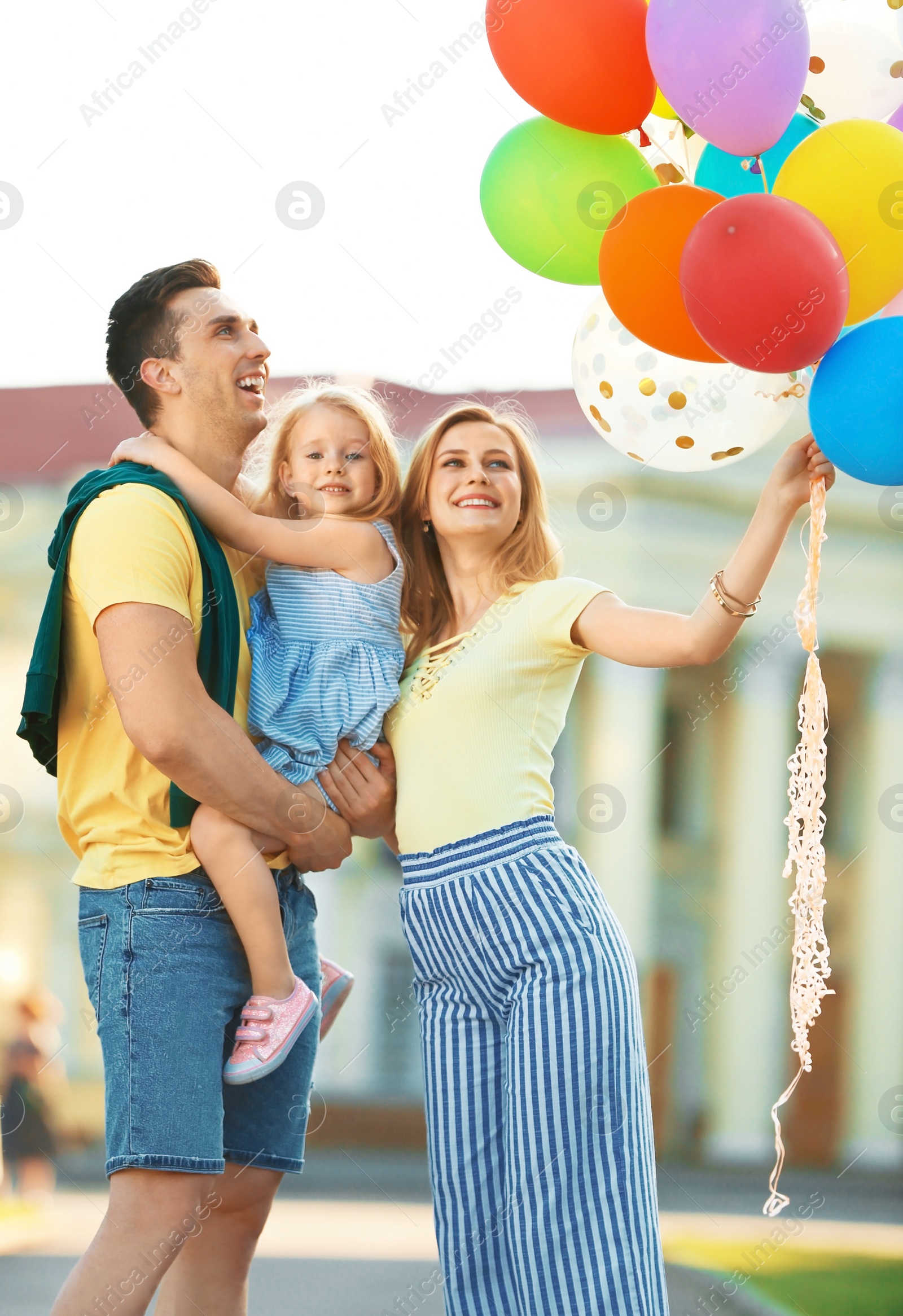 Photo of Happy family with colorful balloons outdoors on sunny day