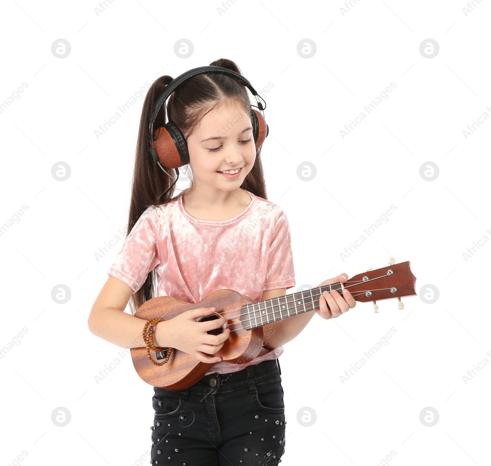 Photo of Portrait of little girl with headphones playing guitar isolated on white