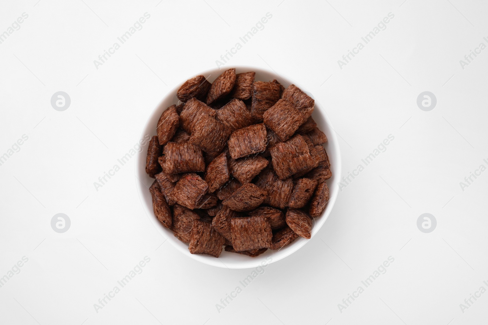 Photo of Chocolate cereal pads in bowl on white table, top view