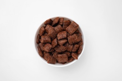 Photo of Chocolate cereal pads in bowl on white table, top view