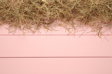 Photo of Heap of dried hay on pink wooden background, flat lay. Space for text