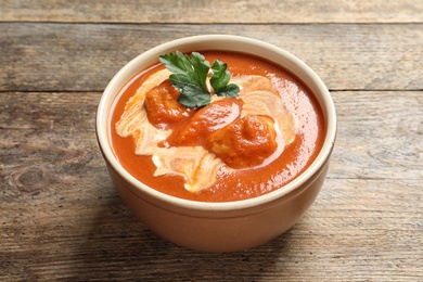 Bowl of delicious butter chicken on wooden table. Traditional indian Murgh Makhani