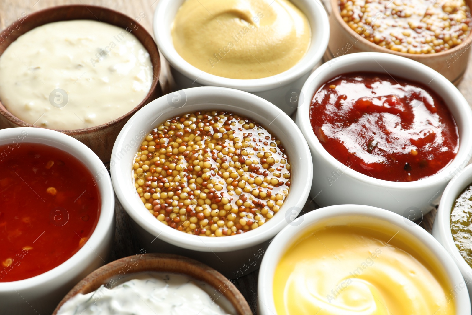 Photo of Set of different delicious sauces as background, closeup