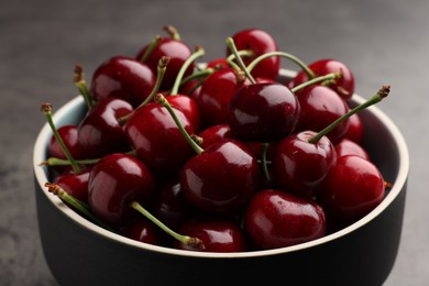 Bowl with ripe sweet cherries on dark grey table, closeup