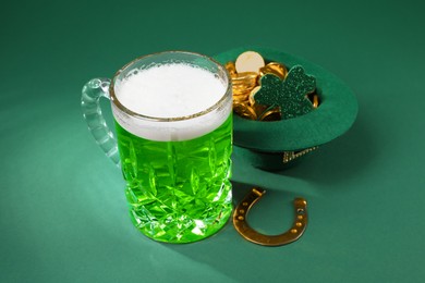 Photo of St. Patrick's day party. Green beer, leprechaun hat with gold, horseshoe and decorative clover leaf on green background