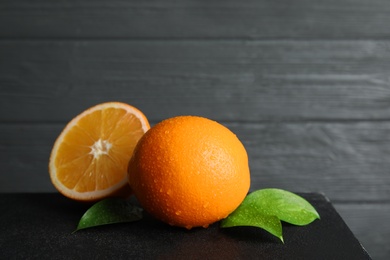 Fresh oranges with leaves on table. Space for text