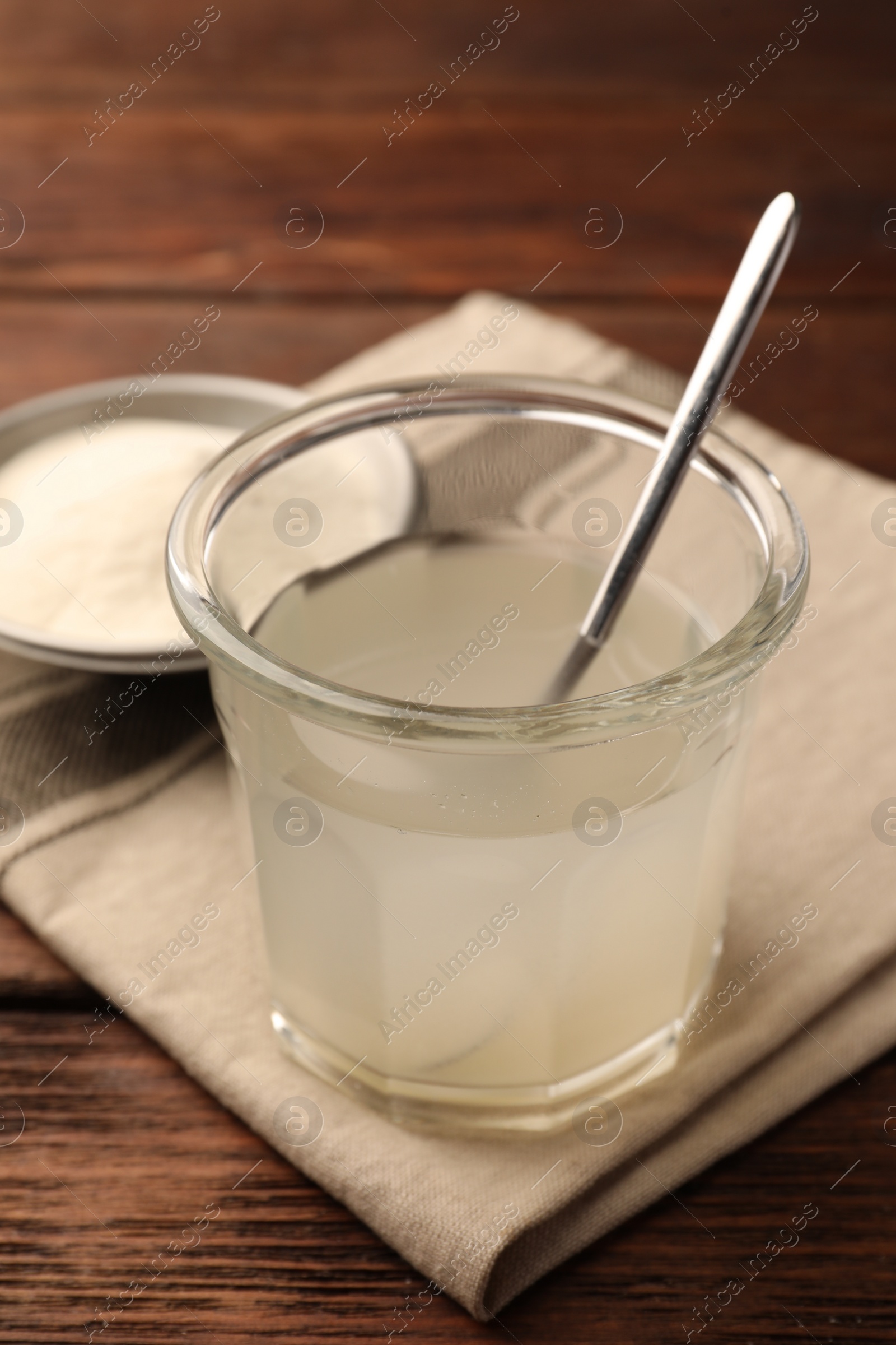 Photo of Glass of agar-agar jelly on wooden table