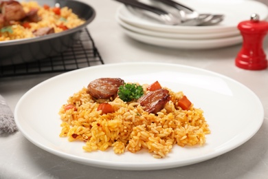 Photo of Plate of tasty rice pilaf with meat on table