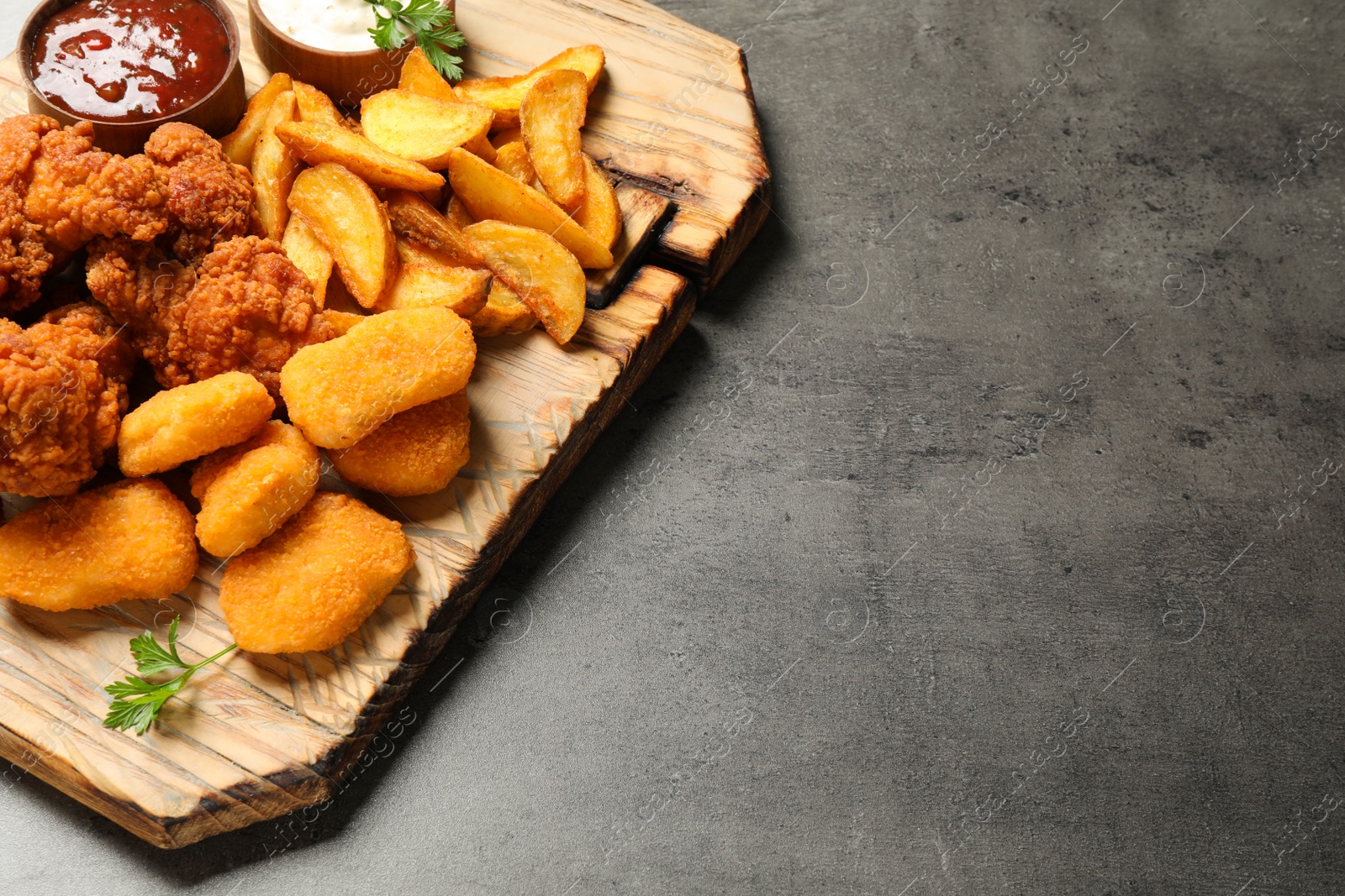 Photo of Tasty fried chicken nuggets served on grey table