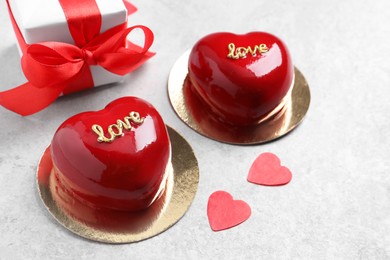 St. Valentine's Day. Delicious heart shaped cakes and gift on light table, closeup