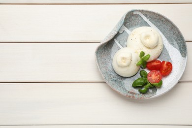 Photo of Delicious burrata cheese with basil and tomatoes on white wooden table, top view. Space for text