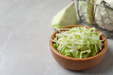 Photo of Fresh shredded cabbage on light table. Space for text