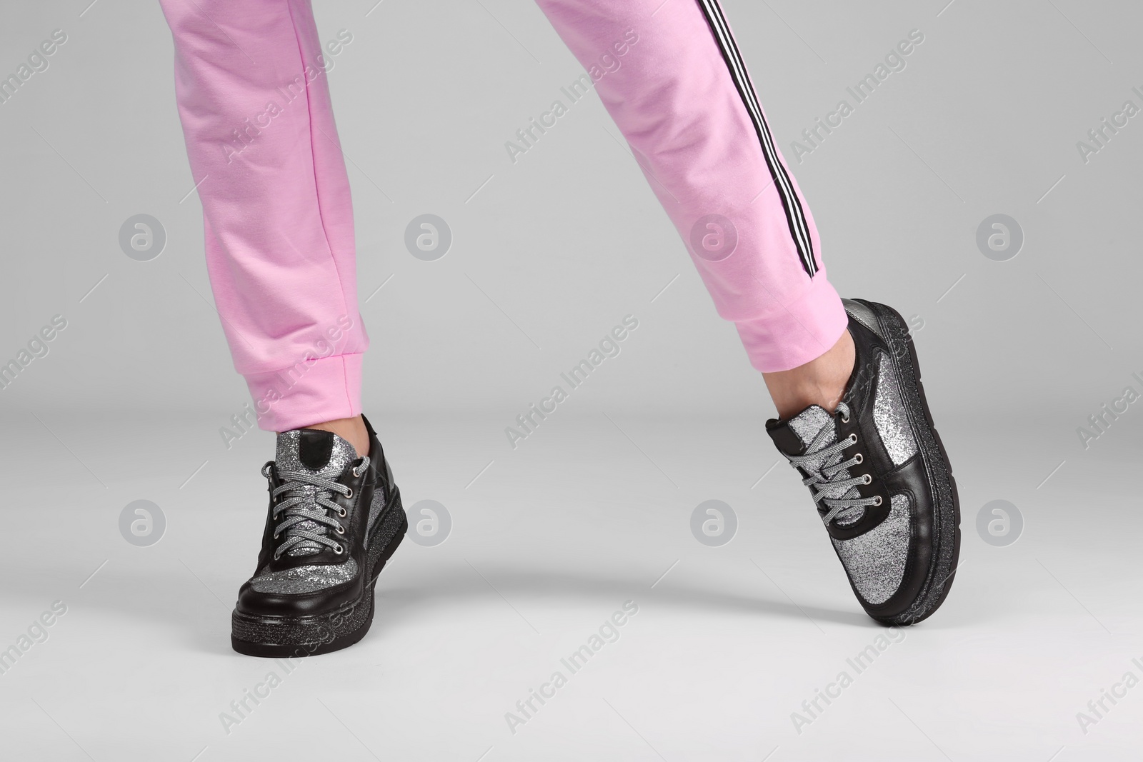 Photo of Woman in stylish sport shoes on light background