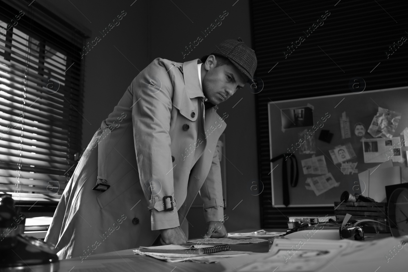Photo of Old fashioned detective working in office. Black and white effect