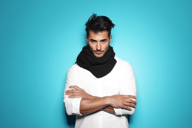 Young man with trendy hairstyle posing on color background