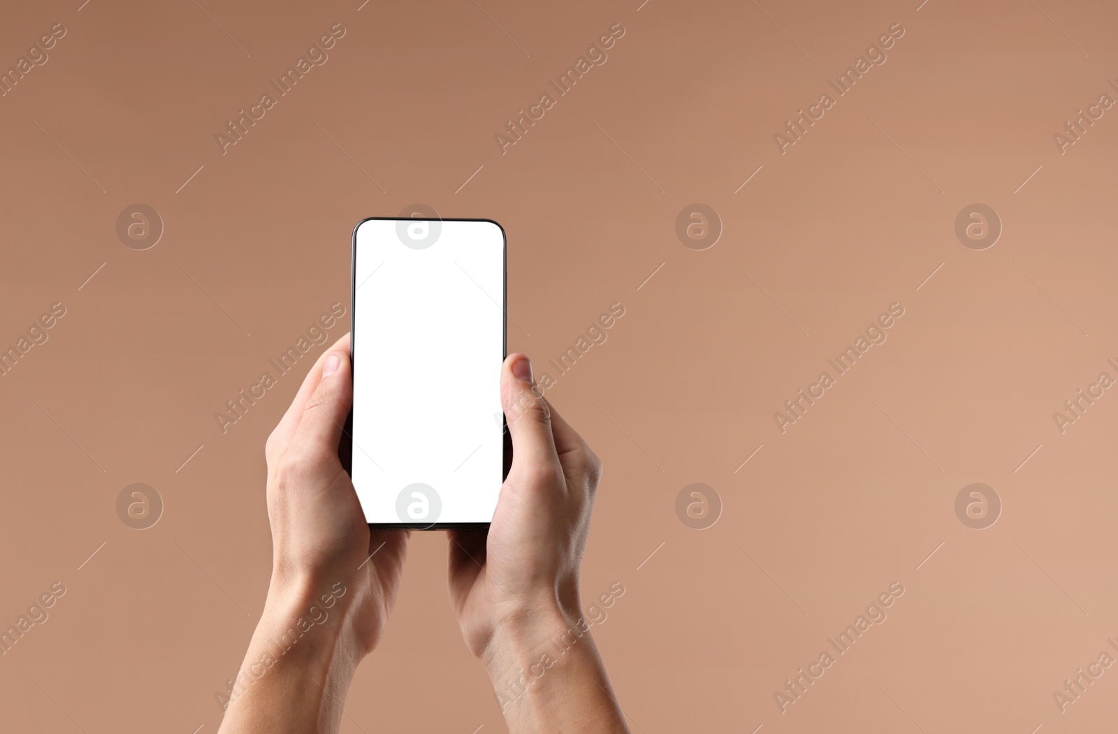 Photo of Man holding smartphone with blank screen on beige background, closeup. Mockup for design