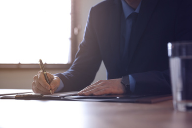 Male lawyer working at table in office, closeup