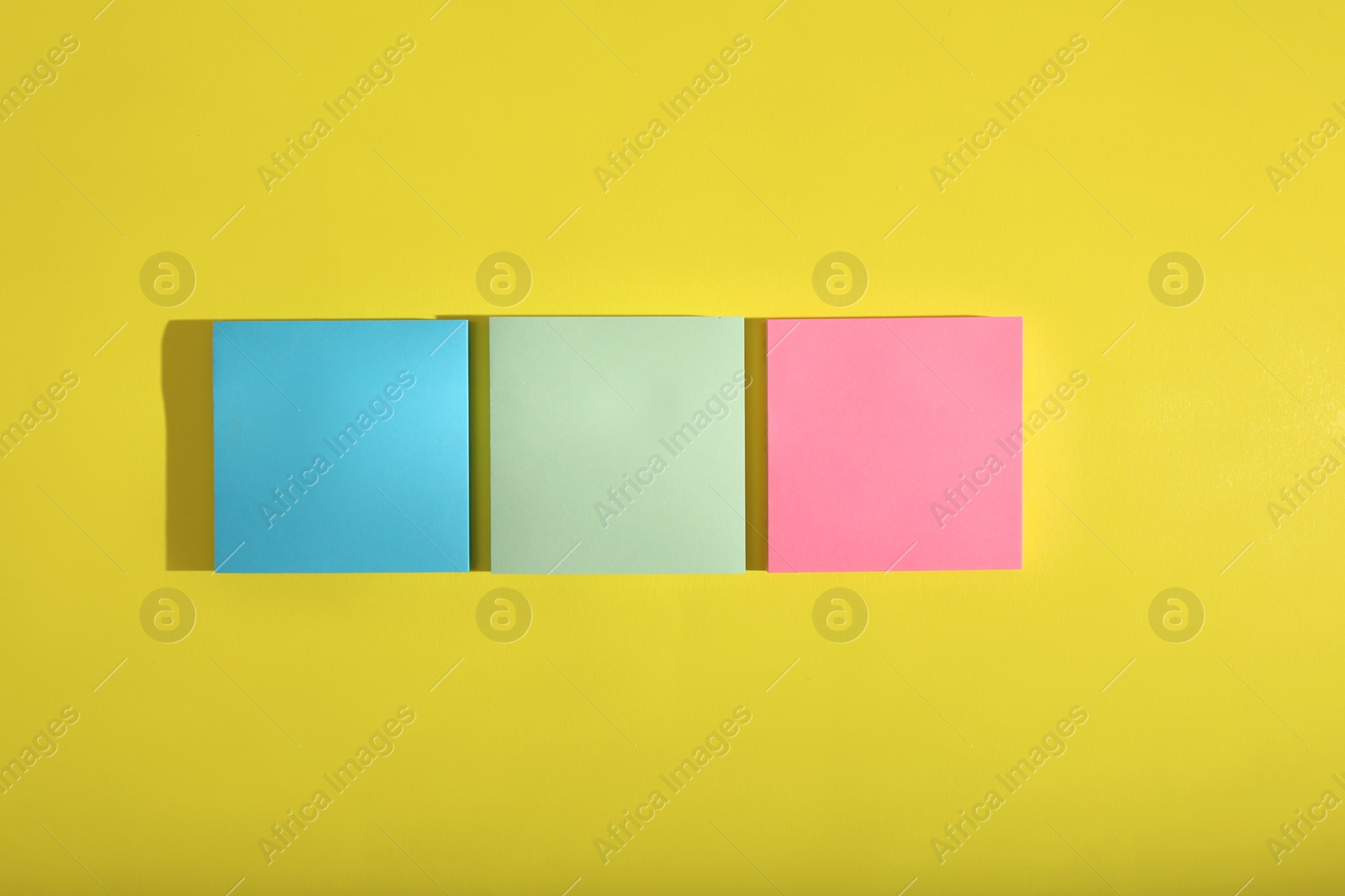 Photo of Colorful sticky notes on yellow background, flat lay