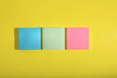 Colorful sticky notes on yellow background, flat lay