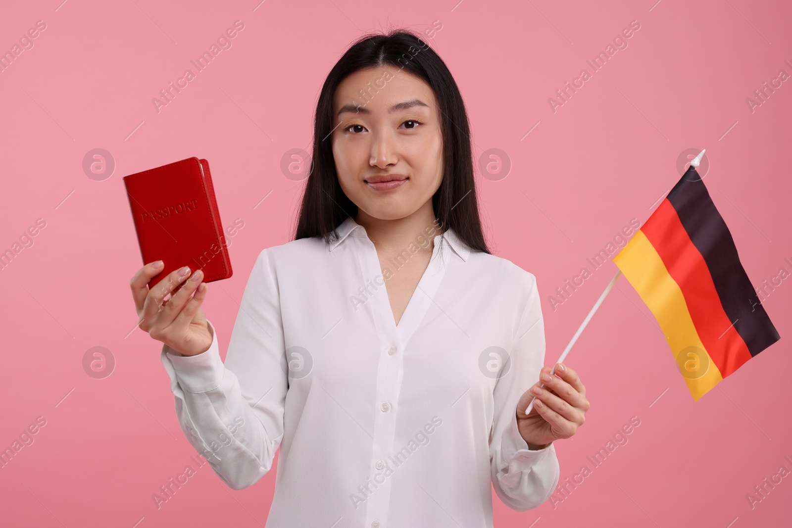 Photo of Immigration to Germany. Woman with passport and flag on pink background