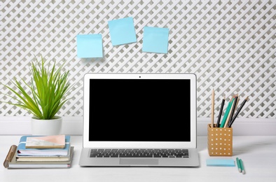 Photo of Laptop with blank screen on office table. Mock up for design