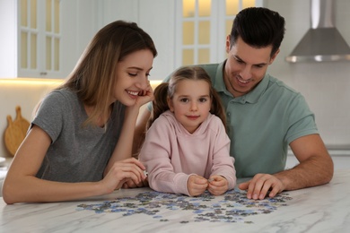 Photo of Happy family playing with puzzles at home