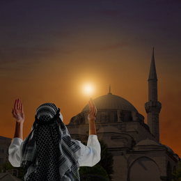 Image of Muslim man praying near mosque at sunset