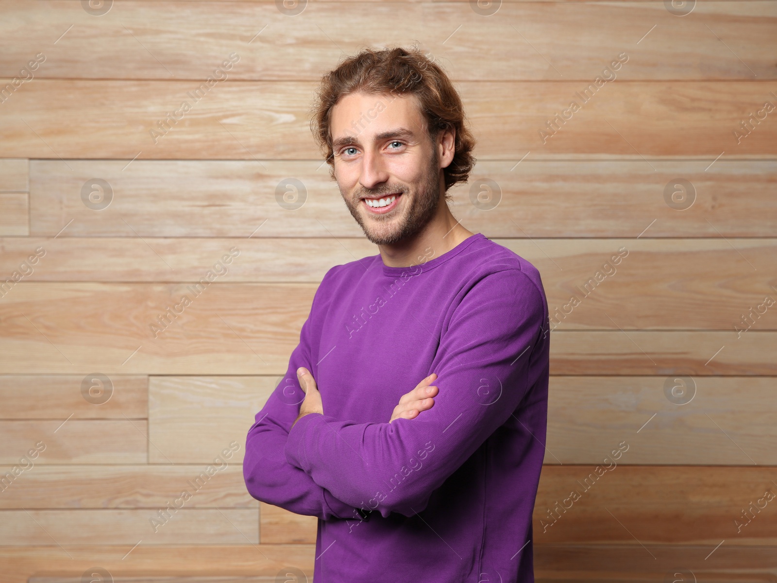 Photo of Handsome young man in warm sweater on wooden background