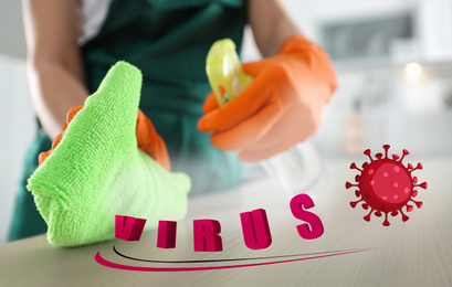 Image of Cleaning vs viruses. Woman washing table with rag and disinfecting solution