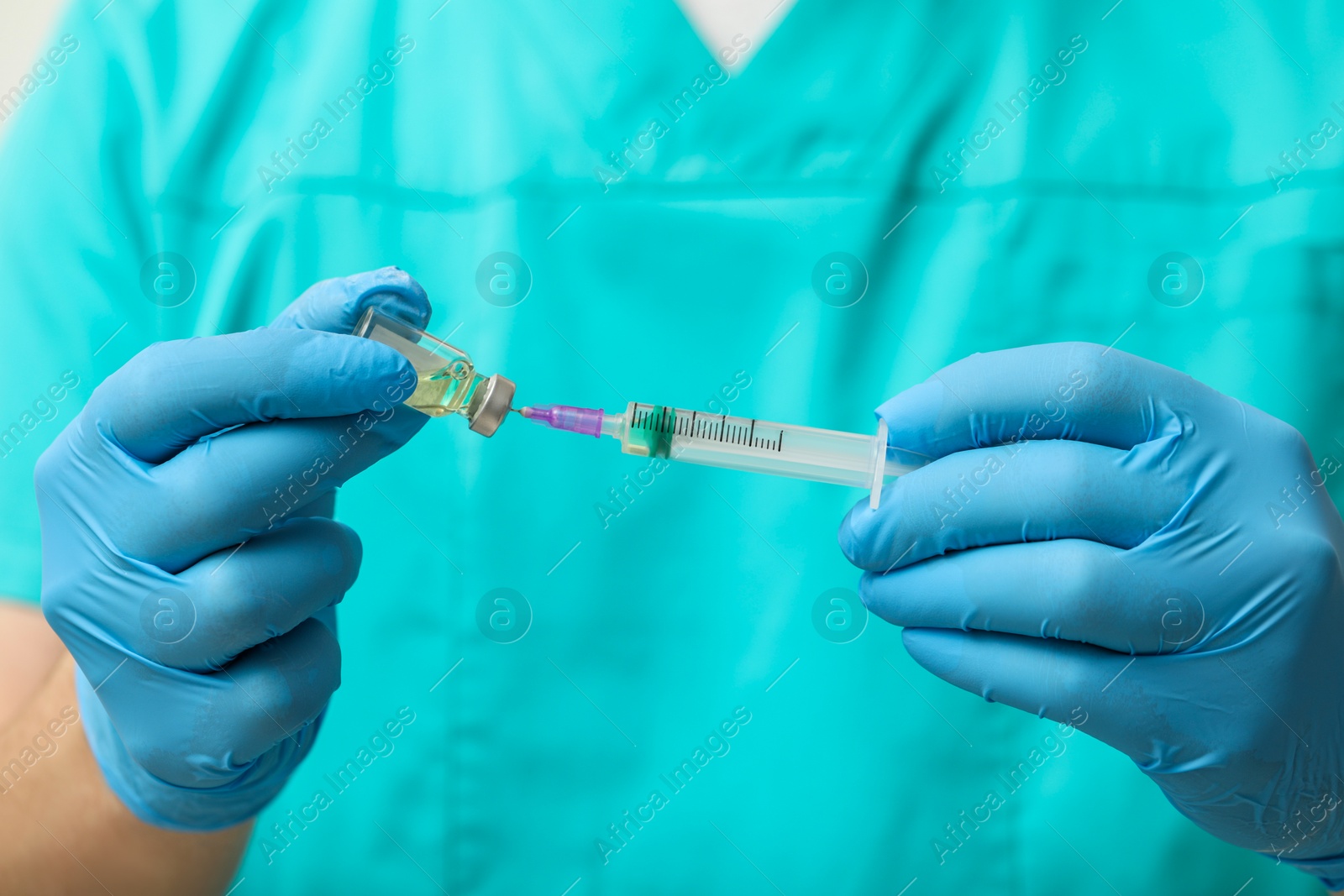 Photo of Doctor filling syringe with hepatitis vaccine from glass vial, closeup