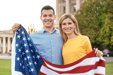 Photo of Couple with American flag on city street