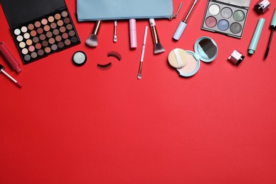 Photo of Decorative cosmetic products on red background, flat lay. Space for text