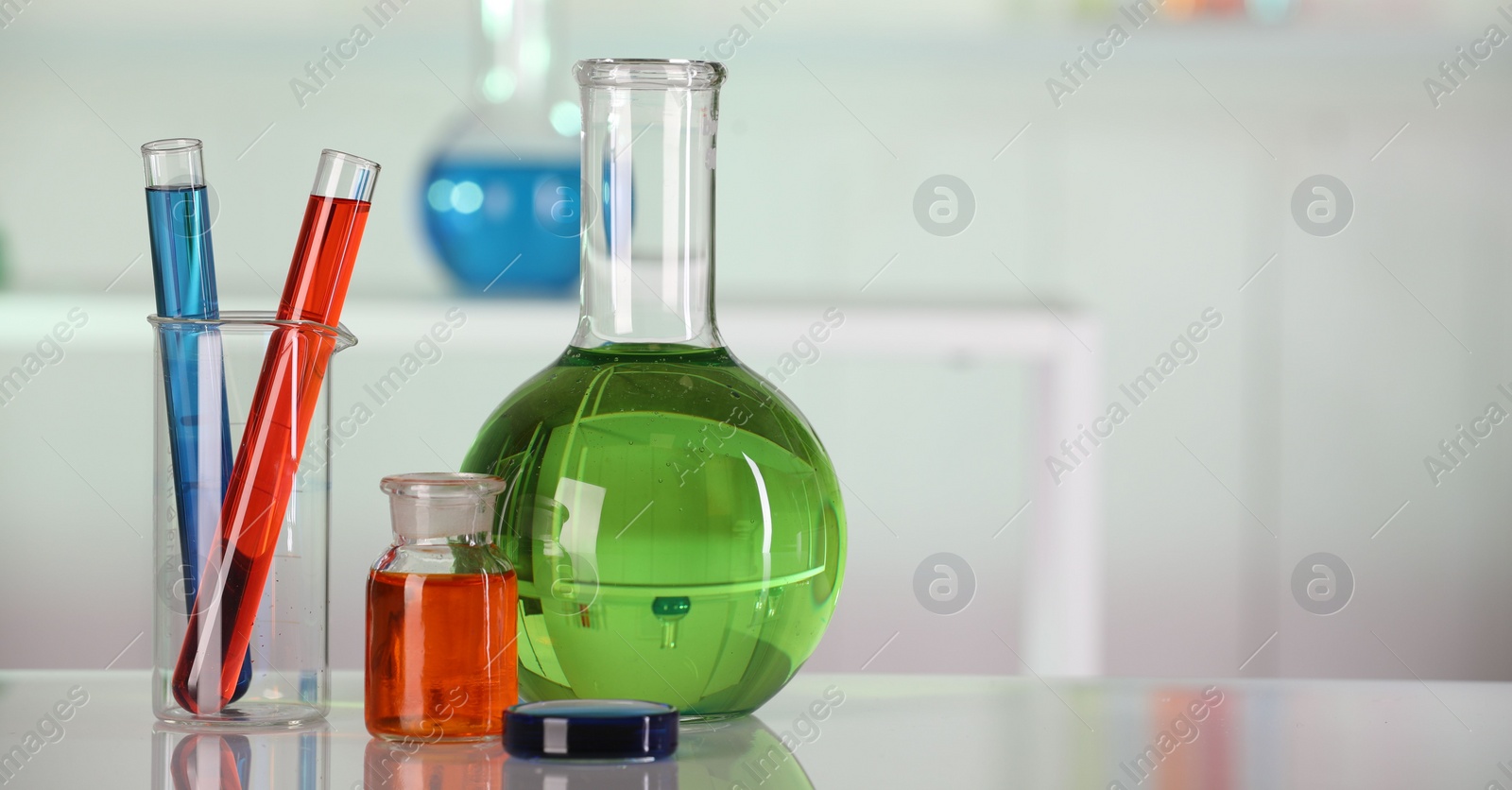 Photo of Laboratory analysis. Different glassware with liquids on white table indoors. Space for text