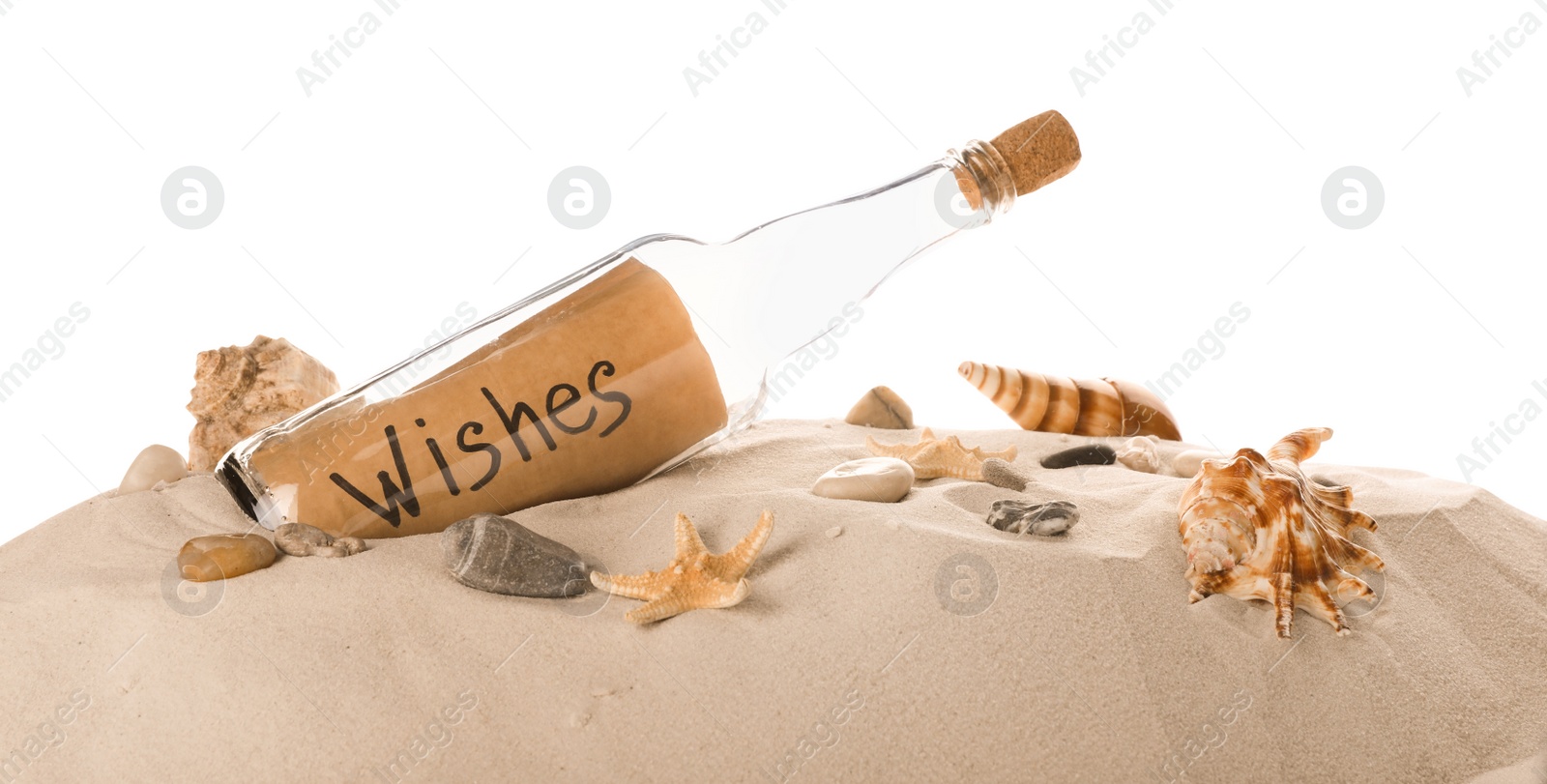 Photo of Corked glass bottle with Wishes note and seashells on sand against white background