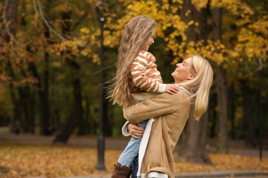 Photo of Happy mother spending time together with her daughter in autumn park