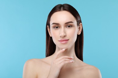 Portrait of beautiful young woman on light blue background